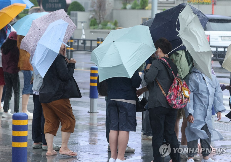 장마가 시작된 1일 부산 해운대구 구남로 횡단보도에서 우산을 쓴 관광객들이 신호를 기다리고 있다. 연합