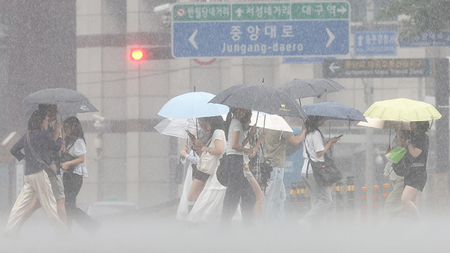 17일 대구 중구 동성로에서 시민들이 우산을 쓰고 쏟아지는 장맛비를 피하며 이동하고 있다.연합